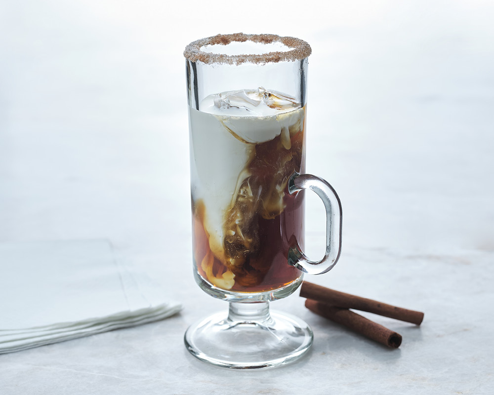 Kahlua Horchata Cocktail with cinnamon sticks on a white gray background