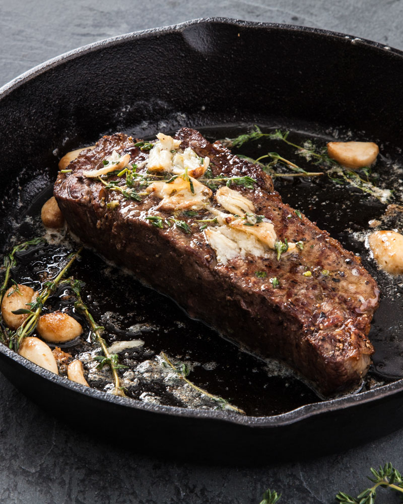 pan fried new york beef steak with garlic and herbs