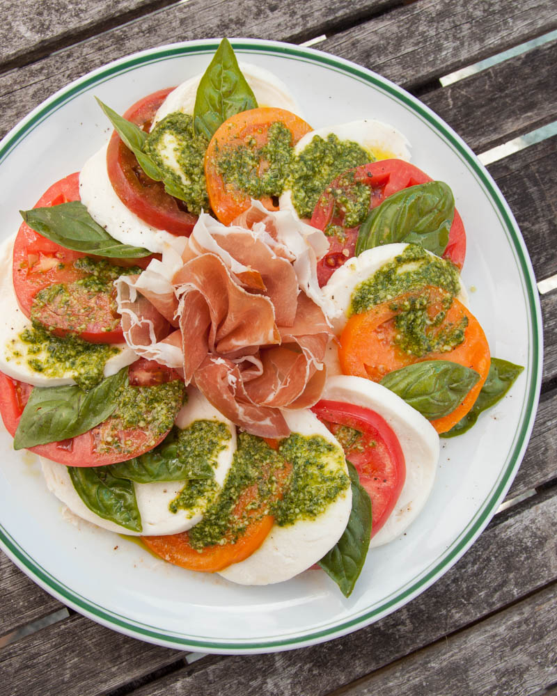 heirloom tomato and prosciutto caprese with pesto vinaigrette