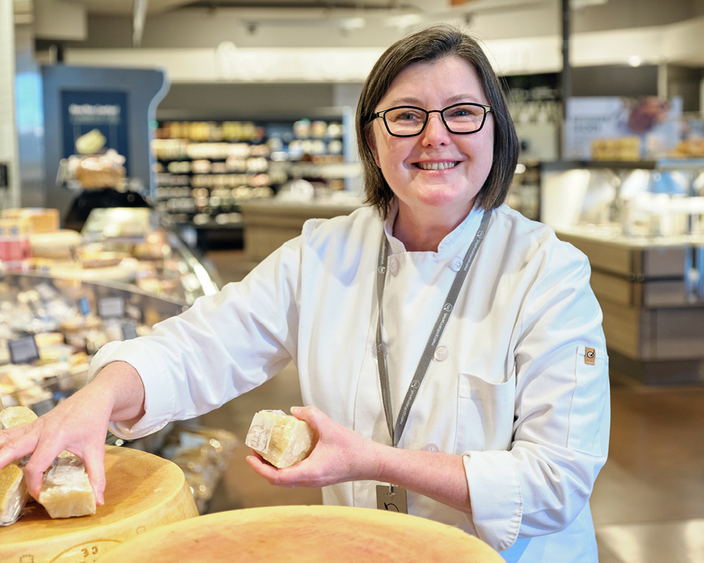 Kim Martin smiling in our store with cheese