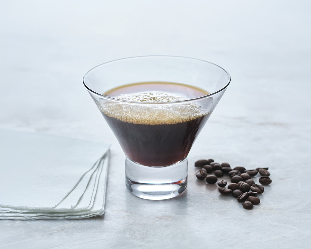 Nitro Brew Martini Cocktail with espresso beans on a gray white background