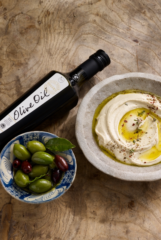 Best of Met Organic Extra Virgin Olive Oil next to hummus and olives