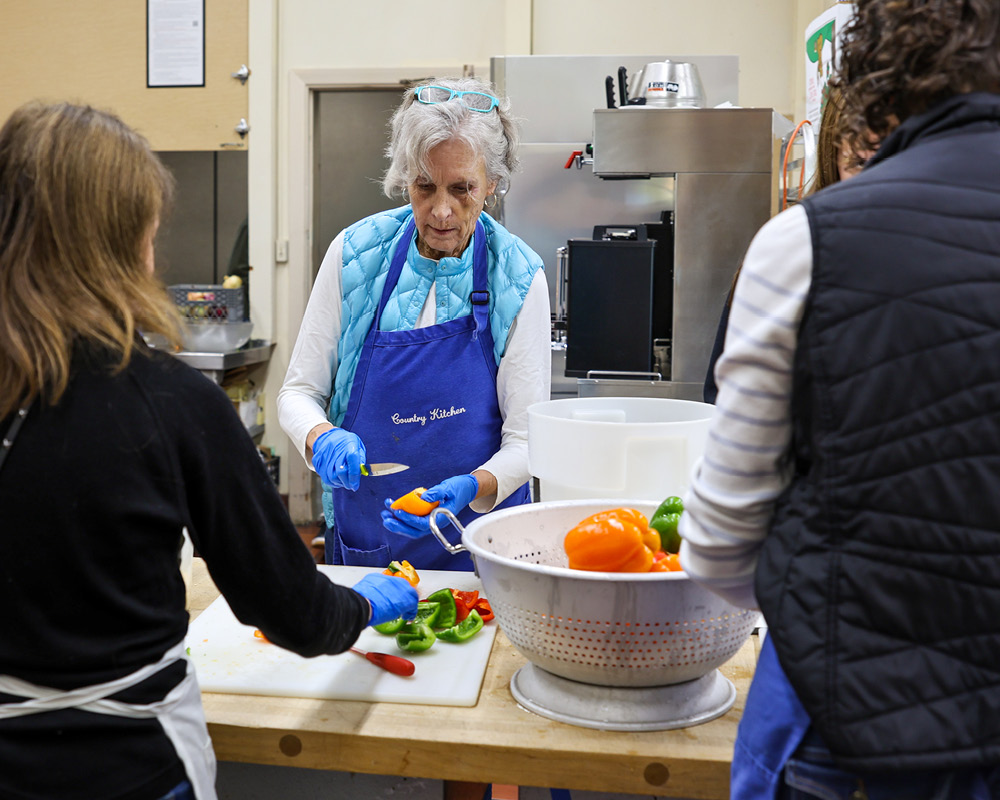 Volunteers peeling vegetables in a kitchen