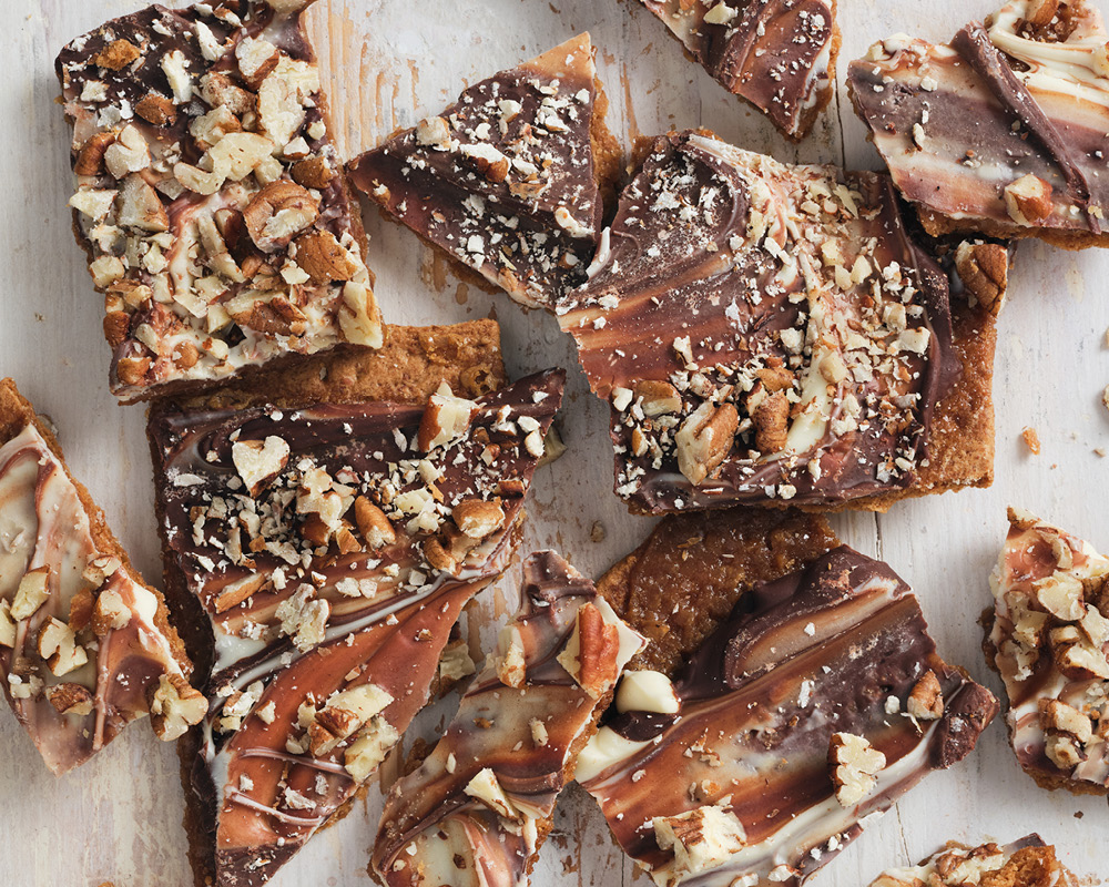 Chocolate toffee graham cookies scattered on white wood table