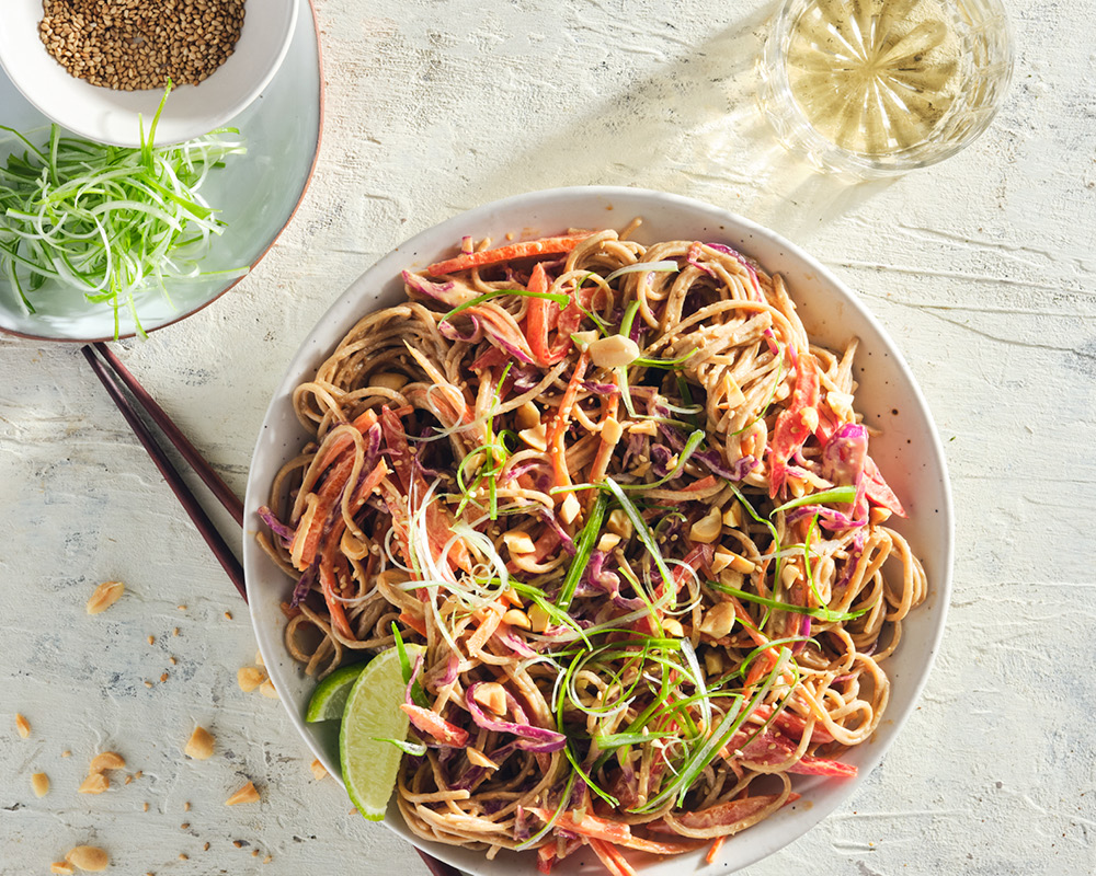 Soba noodle salad on textured white surface