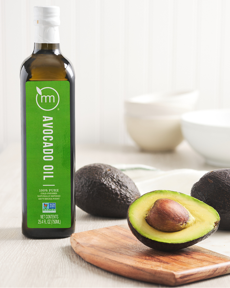 Avocado oil bottle styled with avocados