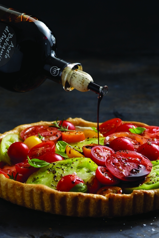 Balsamic Vinegar being poured on heirloom tomato tart
