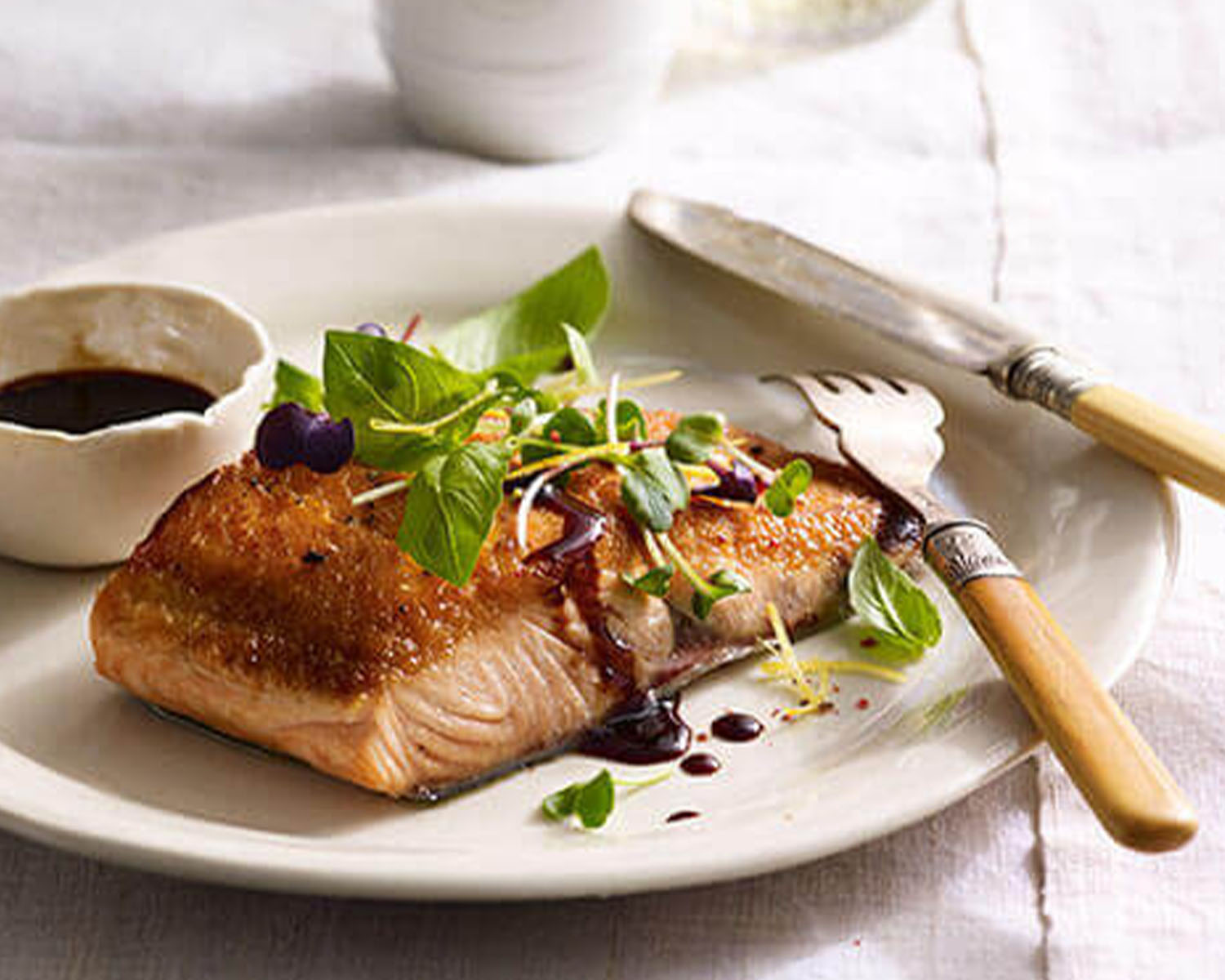 Cooked piece of salmon topped with micro-greens.