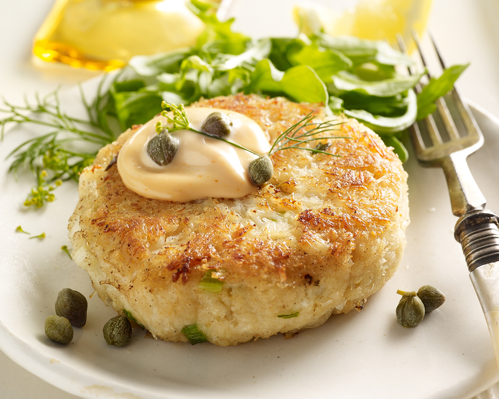 Dungeness crab cake with capers, aioli, and a side of greens