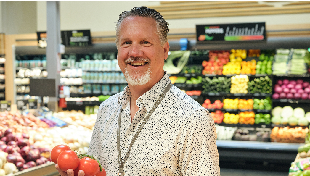 Metropolitan Market Team Member in front of produce section