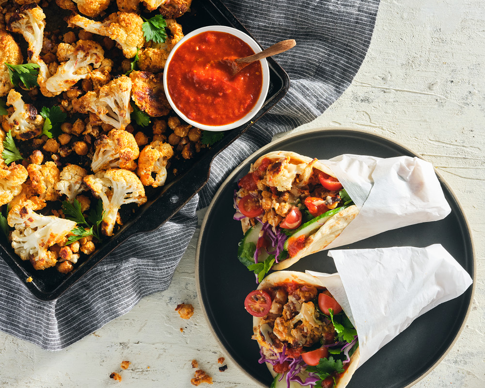 Sheet-pan roasted chickpea and cauliflower pita with harissa sauce